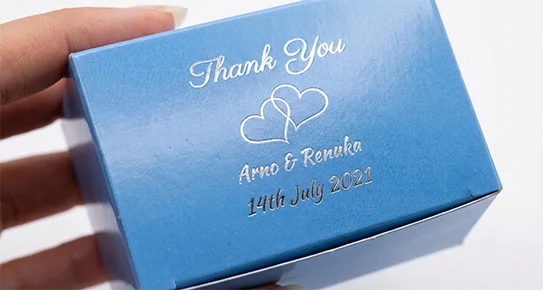 Close-up of sharp silver foil stamping on a vibrant blue bleached cardboard box, showcasing precision detailing for custom gift packaging.